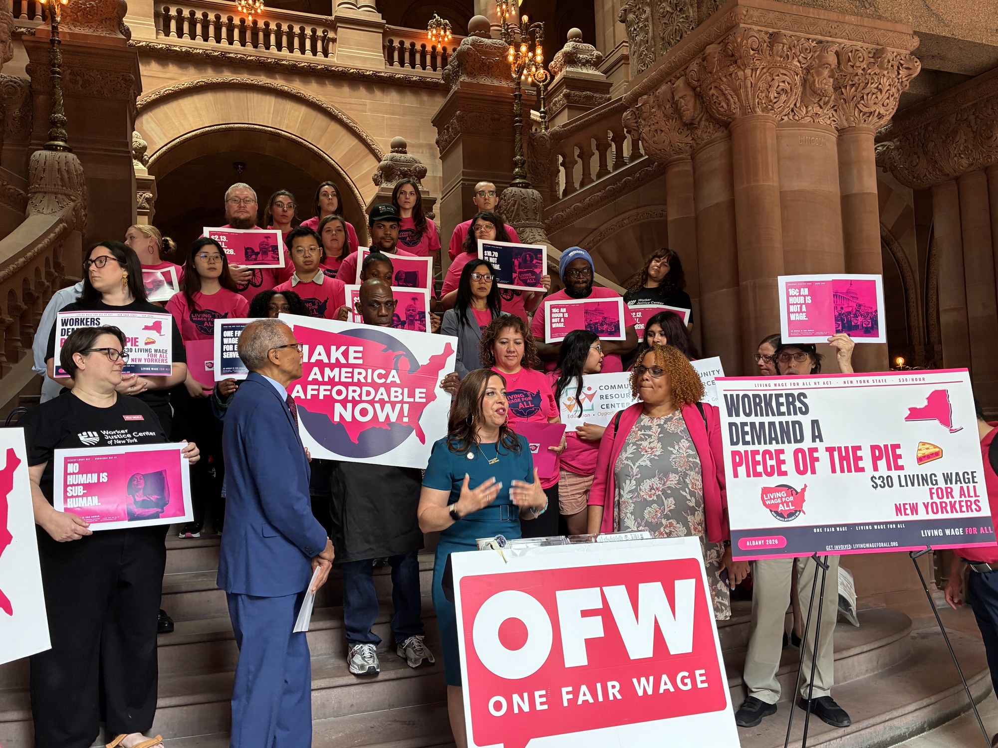 Asm. Jessica Gonz&aacute;lez-Rojas and Sen. Robert Jackson speak at the Living Wage For All NY Coalition Albany Lobby Day on the Million-Dollar Staircase, with OFW members, La Colmena workers, and coalition signs behind them